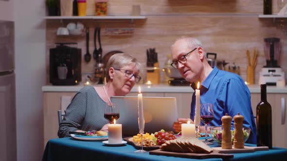 Elderly Couple Using Laptop in the Kitchen