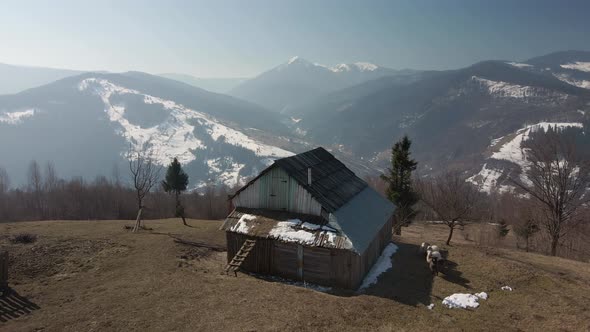 Village House on a Background of Winter Mountains