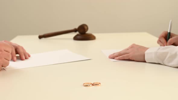 Spouses Sign Divorce Papers in Studio on White Background