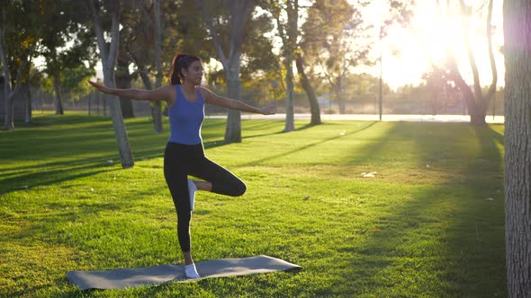 A beautiful young woman yogi almost falling over and losing balance in a one legged prayer hands yog