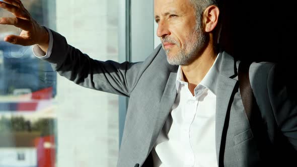 Businessman looking outside the window in hotel room 4k