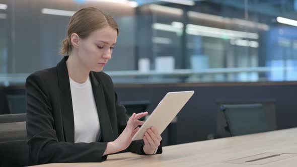 Attractive Businesswoman Using Tablet at Work