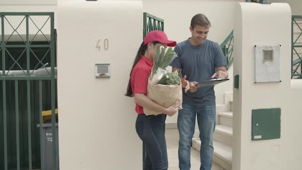 Pretty Courier Girl in Red Uniform Delivering Food