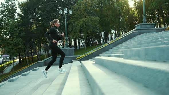 Fit Woman Jogging Upstairs in City Park