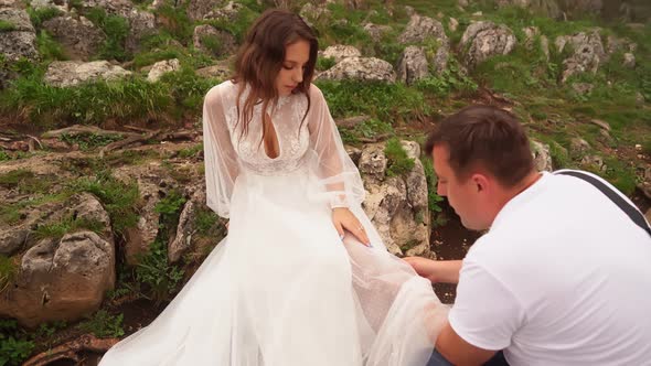 Photo Shoot of a Model in a Wedding Dress in the Mountains in Cold Foggy Weather