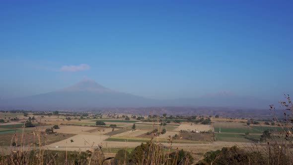 View of Popocatepetl volcanic mountain against the blue sky in 4K
