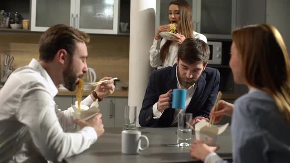 Portrait of Positive People Women and Men Having Lunch Break at Work Eating Noodles From Boxes Using