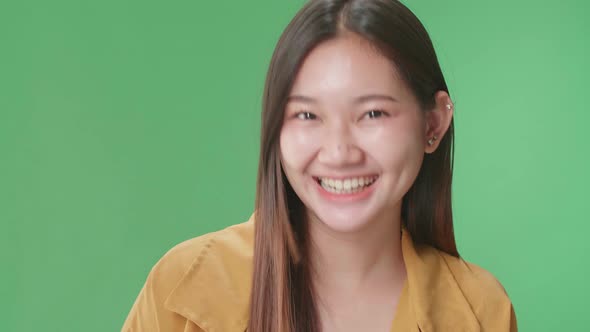 Smiling Asian Woman Positively Shaking Her Head At The Camera In The Green Screen Studio