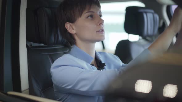 Portrait of Young Pretty Woman in Formal Wear Blue Suit Sitting Inside Car in Front Passanger Seat