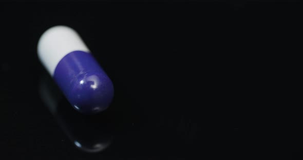 Medicine Pharmacy Concept - Extreme Close Up of Pill Rotating on Black Background