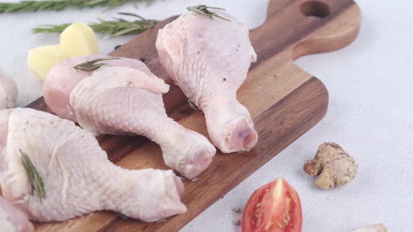 Raw Chicken Drumstick on a Chopping Board