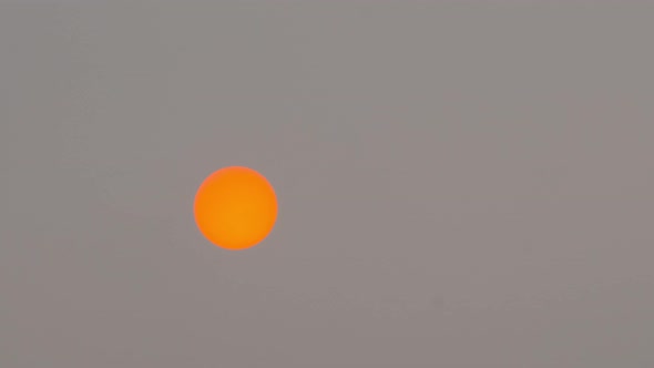 Red sun on a stormy sky, time-lapse