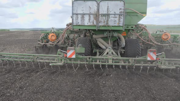 Sowing in the Field. The Seeder Distributes Seeds and Fertilizers Over the Plowed Land. Universal