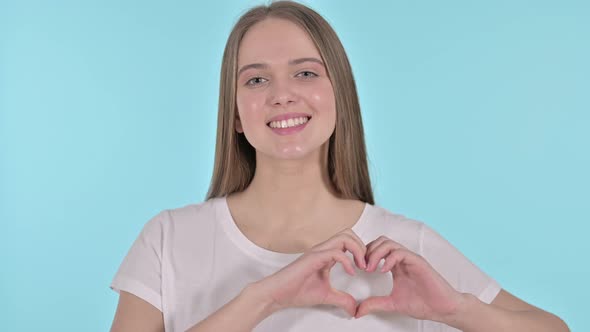 Heart Shape with Hand By Beautiful Young Woman, Blue Background