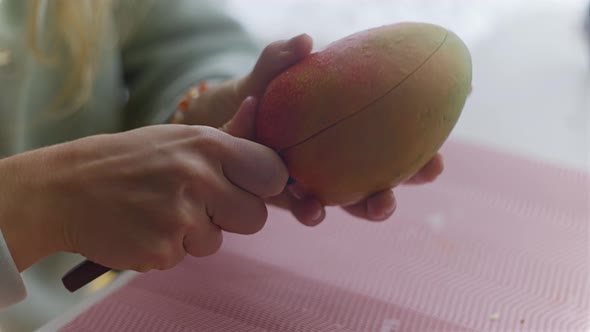 The Woman Cleans Cuts and Eats Mango