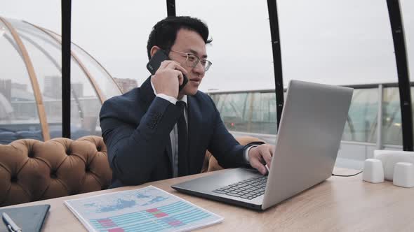 Asian Businessman in Rooftop Cafe