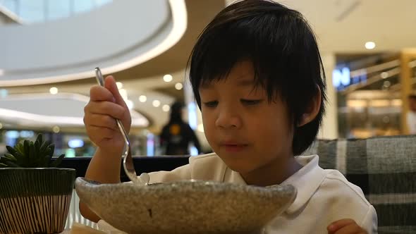 Cute Asian Child Eating Japanese Noodles In A Restaurant