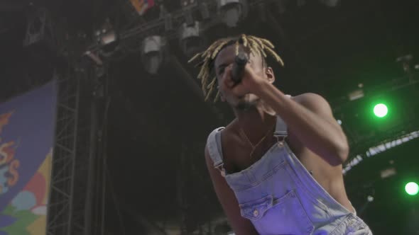 Black rapper in overalls on stage