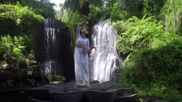 Feminity and Nature Concept Astonishing Woman Dancing in Front of a Huge Majestic Tropical Waterfall