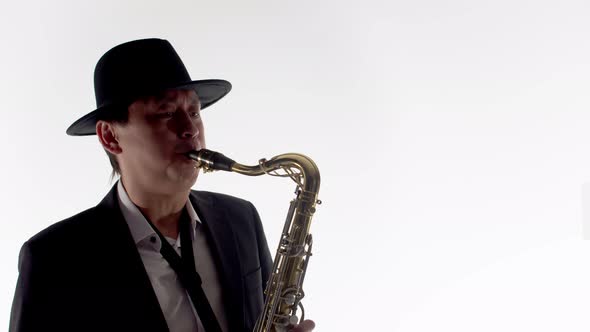 Playing the Saxophone Musician in a Hat and Costume in the Studio