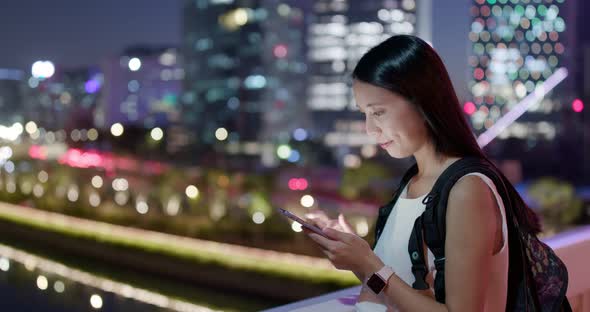 Woman use of mobile phone in city at night