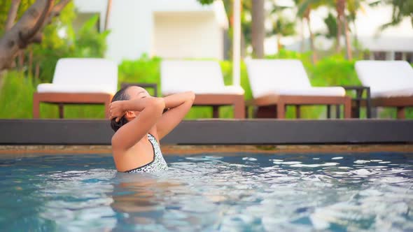 Young asian woman enjoy around outdoor swimming pool for leisure