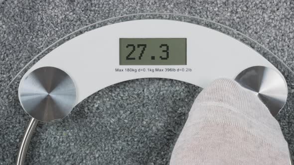 Bathroom Scales with Sad Emoji on the Screen