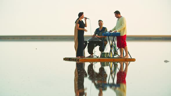 Woman Is Singing To the Music Played By Men with Piano and Hang Drum, Raft, 