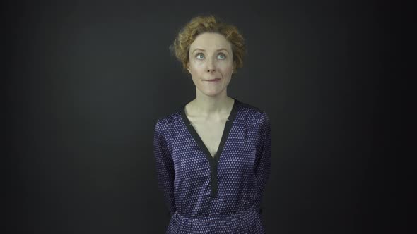 Thoughtful Lady in Polka Dot Dress Looks Around in Studio