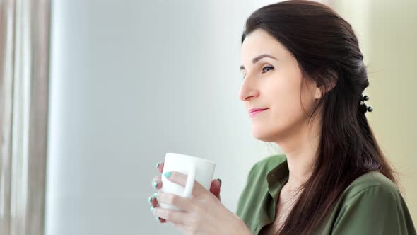 Medium Closeup Pensive Smiling Woman Dreaming Drinking Hot Beverage From White Big Mug