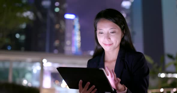 Businesswoman use of tablet computer at night