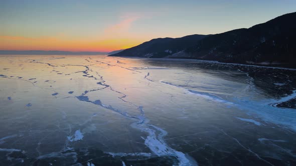 A romantic sunset over an expanse of ice. Lake Baikal on a frosty winter evening