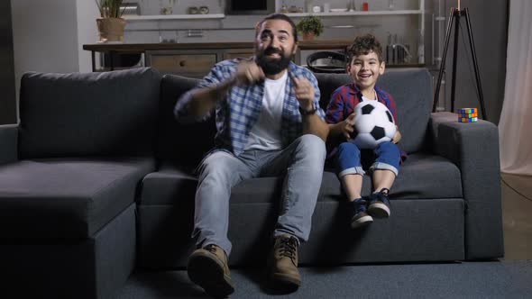 Excited Dad and Son Watching Soccer on Tv at Home