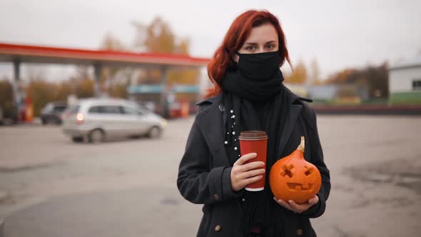 Sad Young Woman Holds Carved Pumpkin and Cup of Coffee