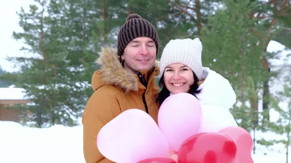 Man and woman in love kissing and hugging on outdoor date in winter