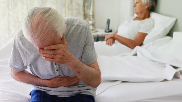 Upset senior couple arguing with each other in bedroom