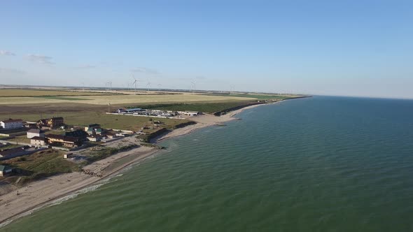 Wind Farm with Wind Mills in Fields on the Water. Aerial Shot