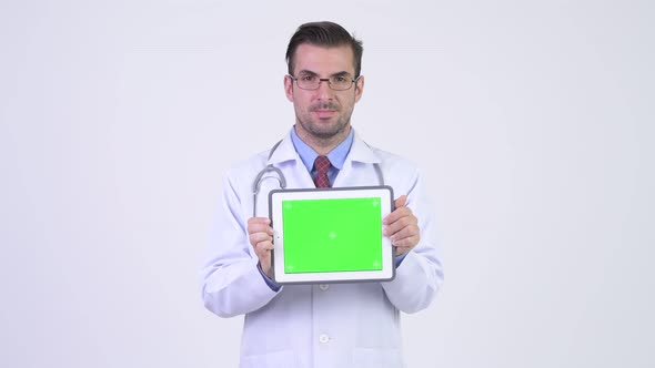 Young Happy Hispanic Man Doctor Showing Digital Tablet