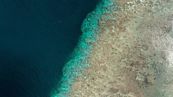 Aerial: flying over tropical Hatta island white sand beach Banda Islands Maluku