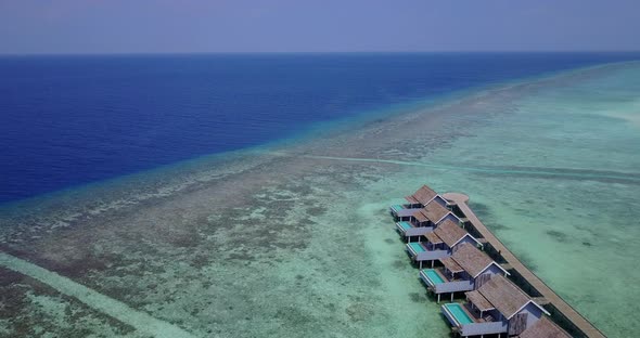 Beautiful overhead tourism shot of a sandy white paradise beach and aqua blue ocean background in hi