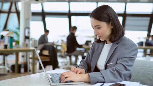 Young Asian Business Woman Manager Using Laptop Working in Big Modern Office