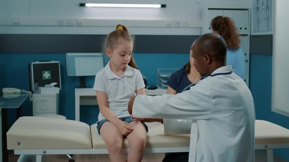 General Practitioner Applying Bandaid on Fractured Arm of Little Girl