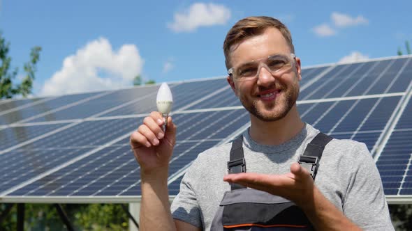 Engineer Standing with Lamp on Solar Panel and Feeling Freedom at View Point