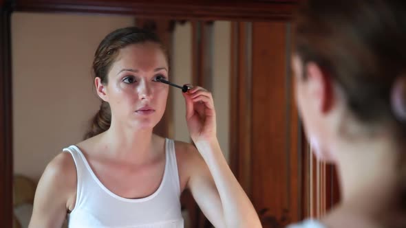 Beautiful Woman at the Mirror Applying Make Up