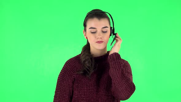 Young Girl Talking on Headphones, Call Center. Green Screen