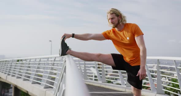 Sporty Caucasian man training on a bridge