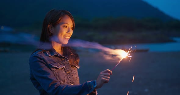 Woman play sparkler at night