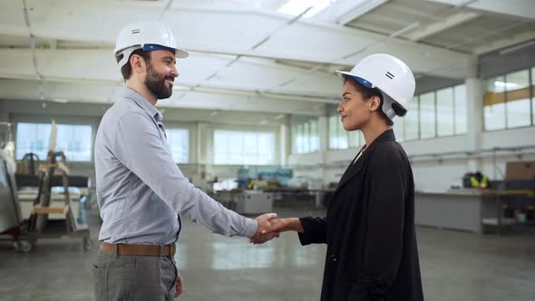 Portrait of Two Business Partners Man and Woman Wearing Helmet and Formal Clothing Shaking Hands As