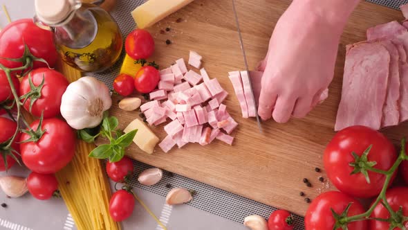 Making Pasta Carbonara Slicing Traditional Pancetta Bacon Into Pieces on a Wooden Cutting Board with