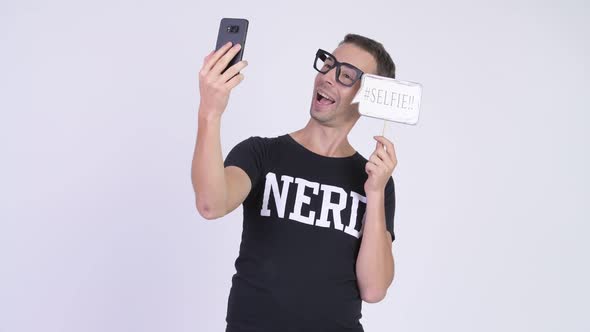 Studio Shot of Happy Nerd Man Taking Selfie with Paper Sign